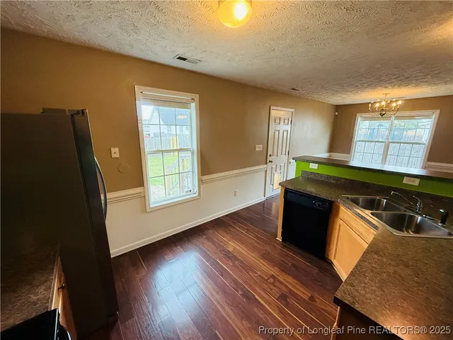 a kitchen with wooden floors and a black appliances