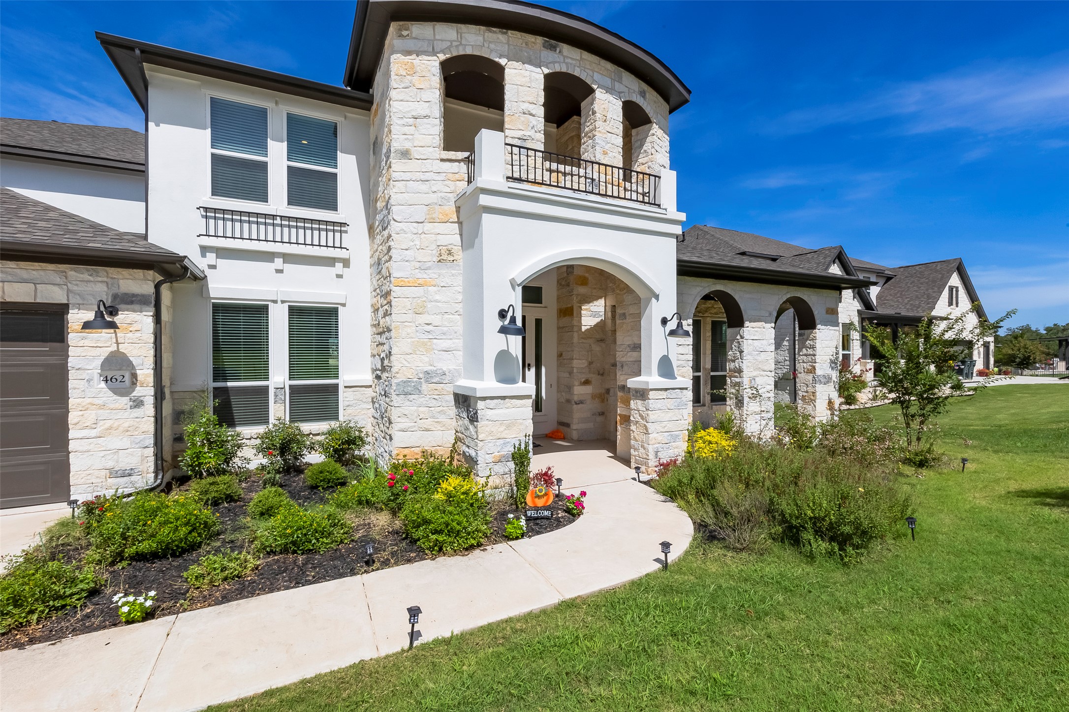 462 Old Stone Road Austin, TX 78737 - Photo 1 of 39 View of front of home with stone siding, a balcony, stucco siding, and a front yard