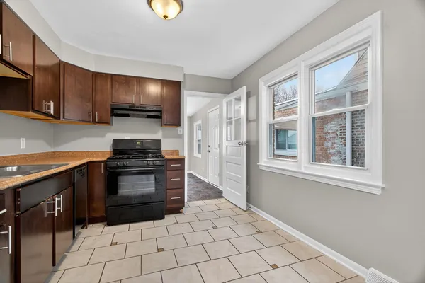 a kitchen with granite countertop a stove a sink and a refrigerator