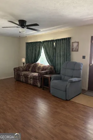 a living room with furniture and a wooden floor