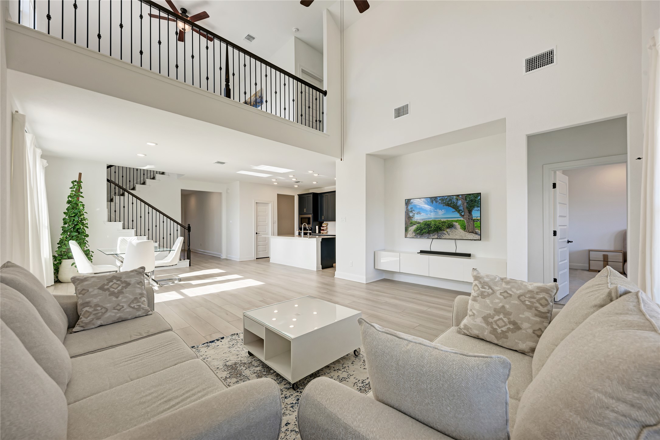 316 Regatta Trail Leander, TX 78641 - Photo 16 of 37 Vaulted living space featuring wood-finish flooring, an open mezzanine, and a contemporary media console
