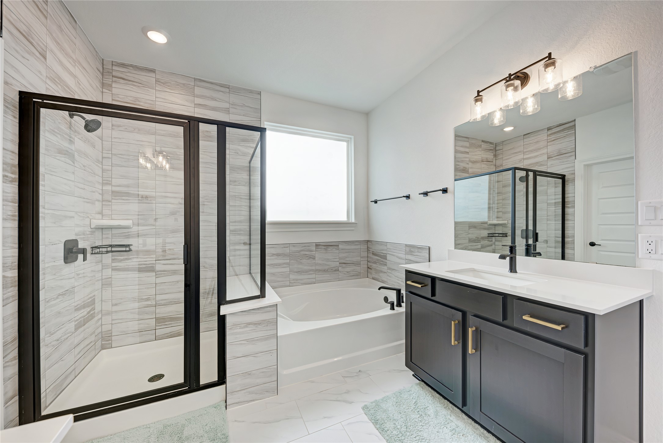 316 Regatta Trail Leander, TX 78641 - Photo 18 of 37 Modern bathroom featuring a walk-in shower with black-framed glass enclosure, tiled walls, and a built-in shelf