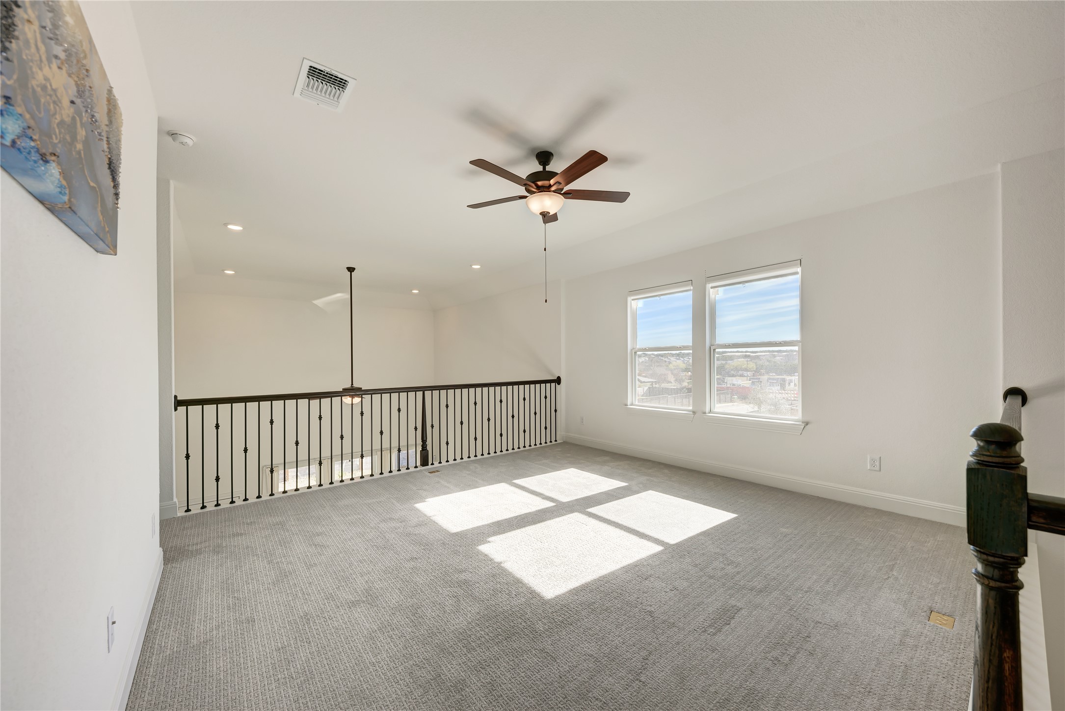 316 Regatta Trail Leander, TX 78641 - Photo 25 of 37 Carpeted loft space featuring dual windows, recessed lighting, and a ceiling fan