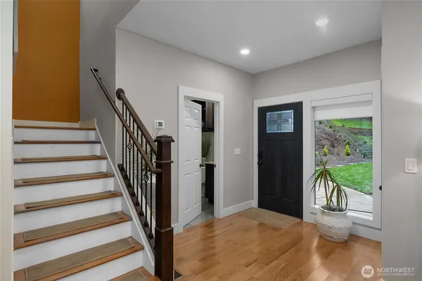 a view of a hallway with wooden floor and stairs
