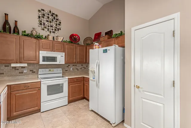 a kitchen with stainless steel appliances granite countertop a refrigerator and a stove