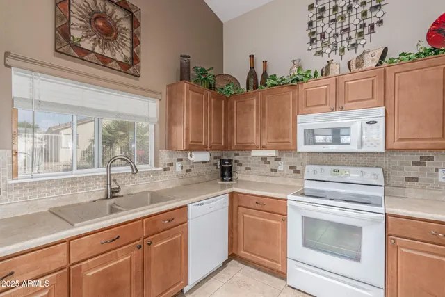 a kitchen with cabinets appliances a sink and a window