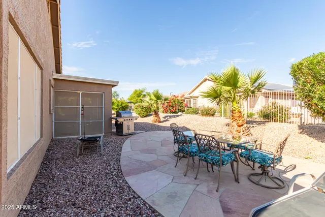 a view of a swimming pool with chairs and table in the patio