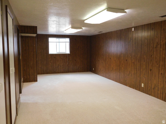 2148 Carolyn Way Bountiful, UT 84010 - Photo 24 of 40 Spacious room featuring wood paneling walls and neutral-toned carpeting