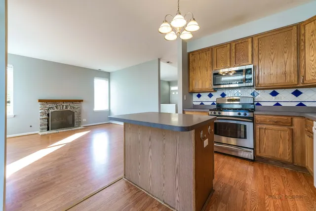 a kitchen with granite countertop stainless steel appliances a refrigerator microwave and stove top oven