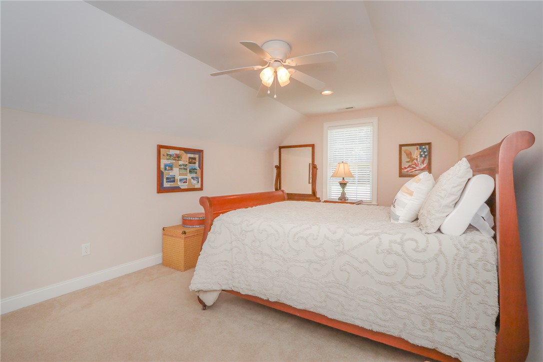 103 C-10-147D Anderson, SC 29621 - Photo 37 of 49 A well-lit bedroom provides a restful retreat, featuring a warm wooden bed frame and a ceiling fan for comfort.