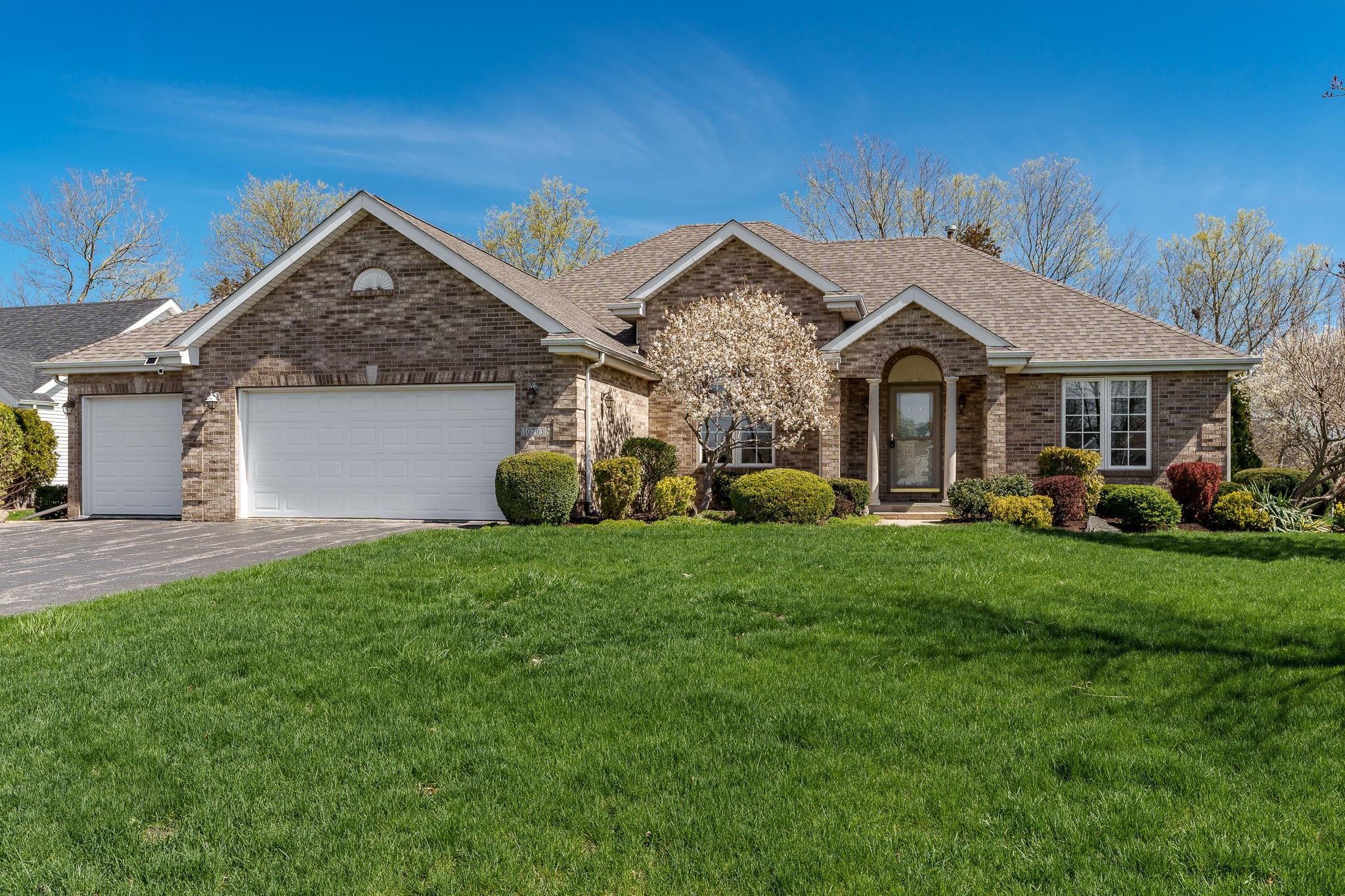 10703 Chicory Ridge Way Roscoe, IL 61073 - Photo 3 of 64 a front view of a house with a garden and plants
