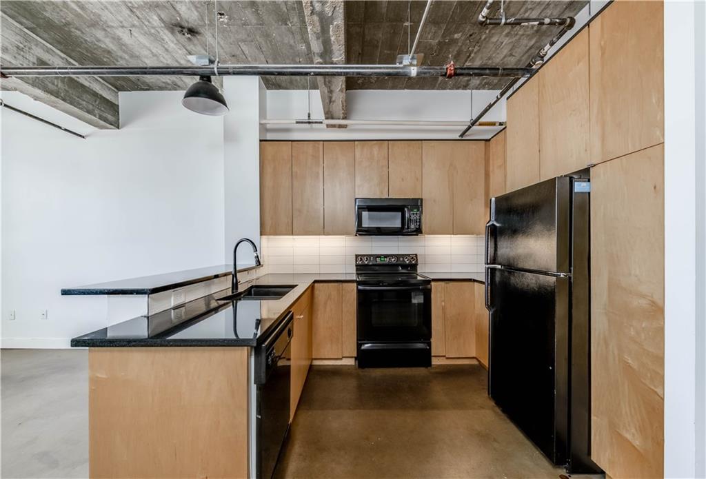 710 Colorado Street, Unit G9 Austin, TX 78701 - Photo 2 of 25 Functional kitchen with exposed ductwork provides an urban-industrial aesthetic.