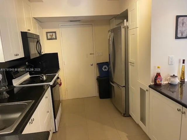 a kitchen with a refrigerator and a stove top oven