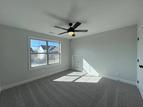 an empty room with a window and a fan