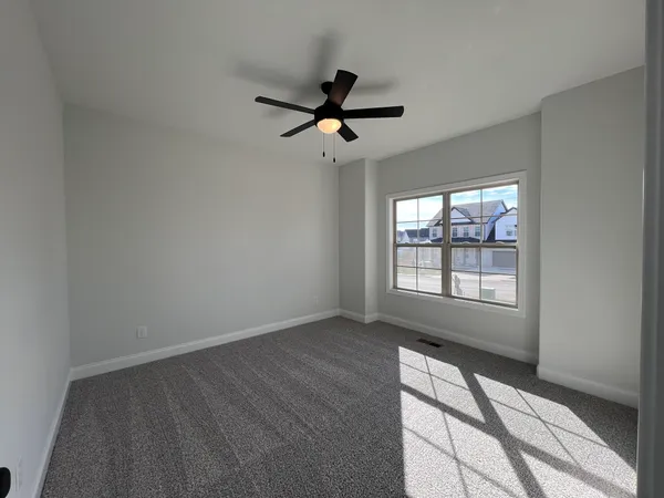 a view of an empty room with wooden floor fireplace and a window