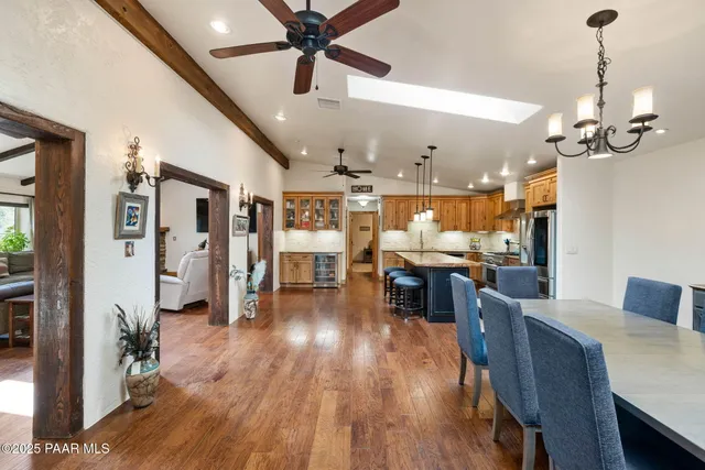 a view of a dining room and livingroom with furniture wooden floor a chandelier