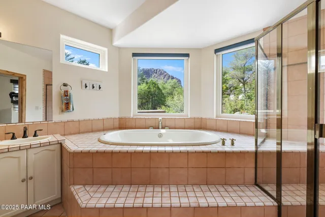 a large white bathroom with a large tub sink and double vanity