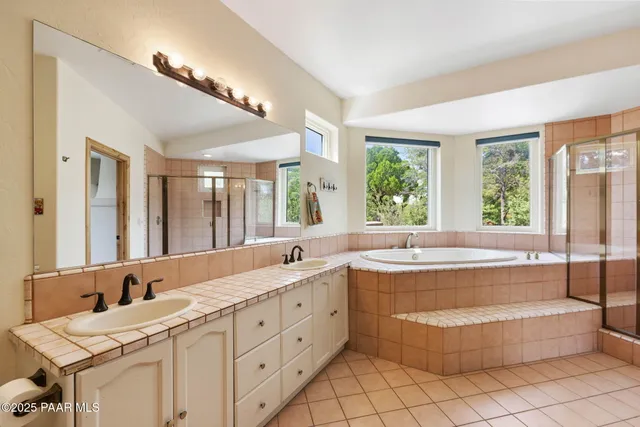 a spacious bathroom with a granite countertop tub shower and sink