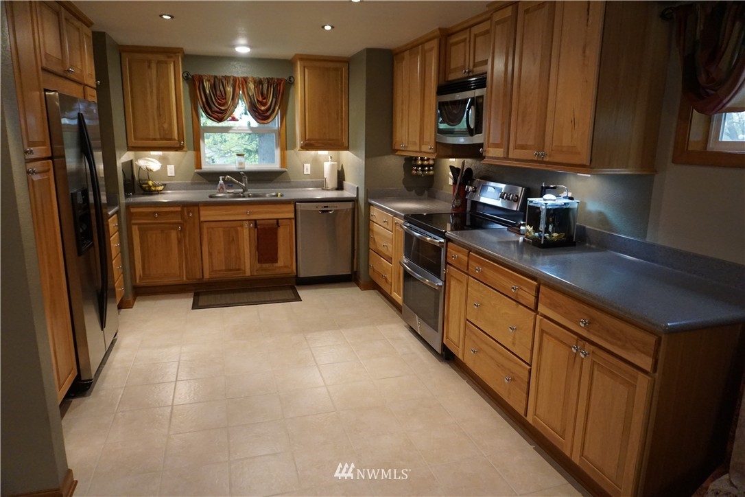 17813 Butler Road Snohomish, WA 98290 - Photo 3 of 23 a kitchen with stainless steel appliances granite countertop a stove a sink dishwasher and a refrigerator