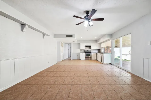 a view of empty room with wooden floor and window