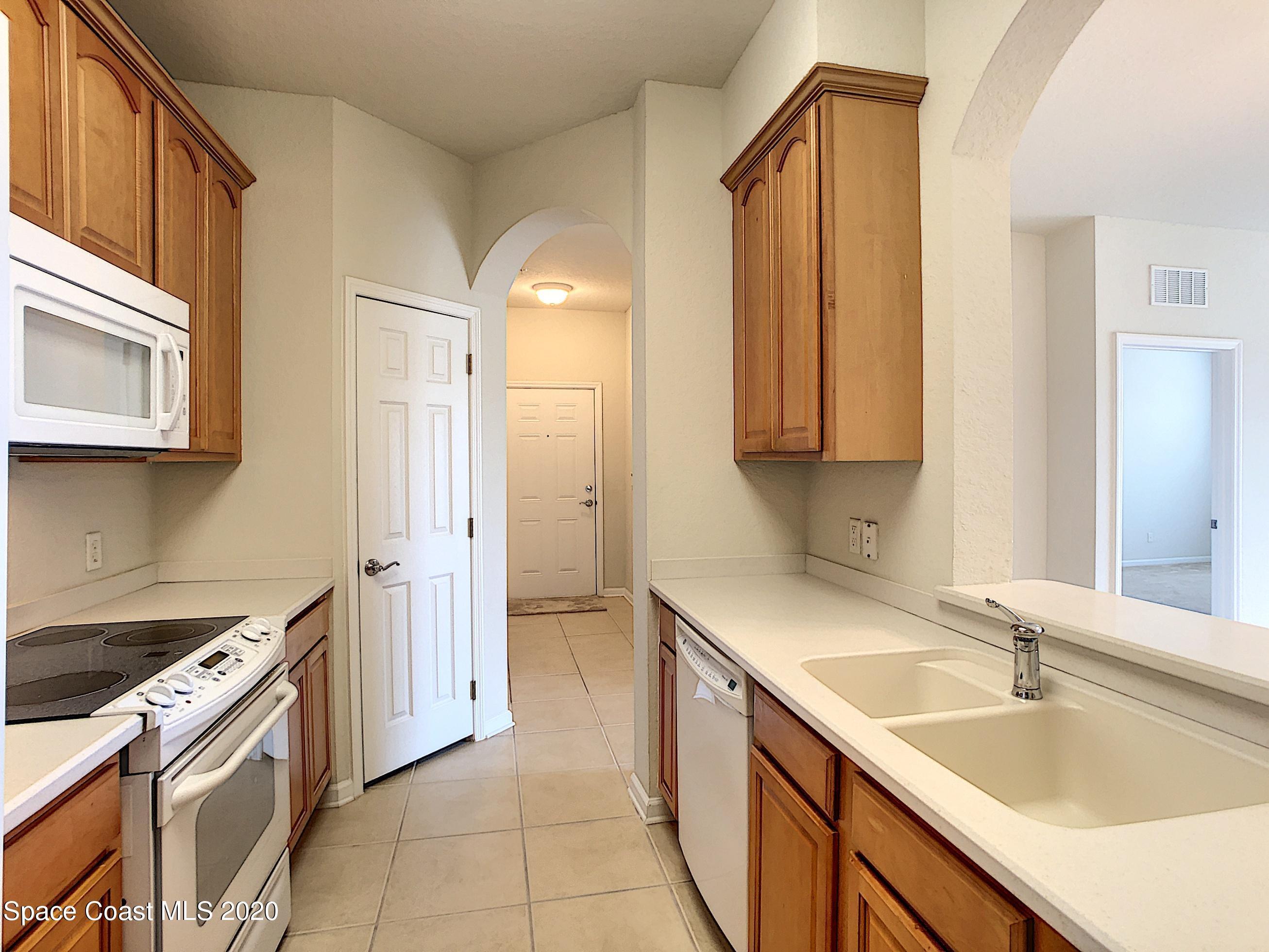 3848 Lexmark Lane, Unit 401 Rockledge, FL 32955 - Photo 5 of 23 a kitchen with a sink stove and cabinets