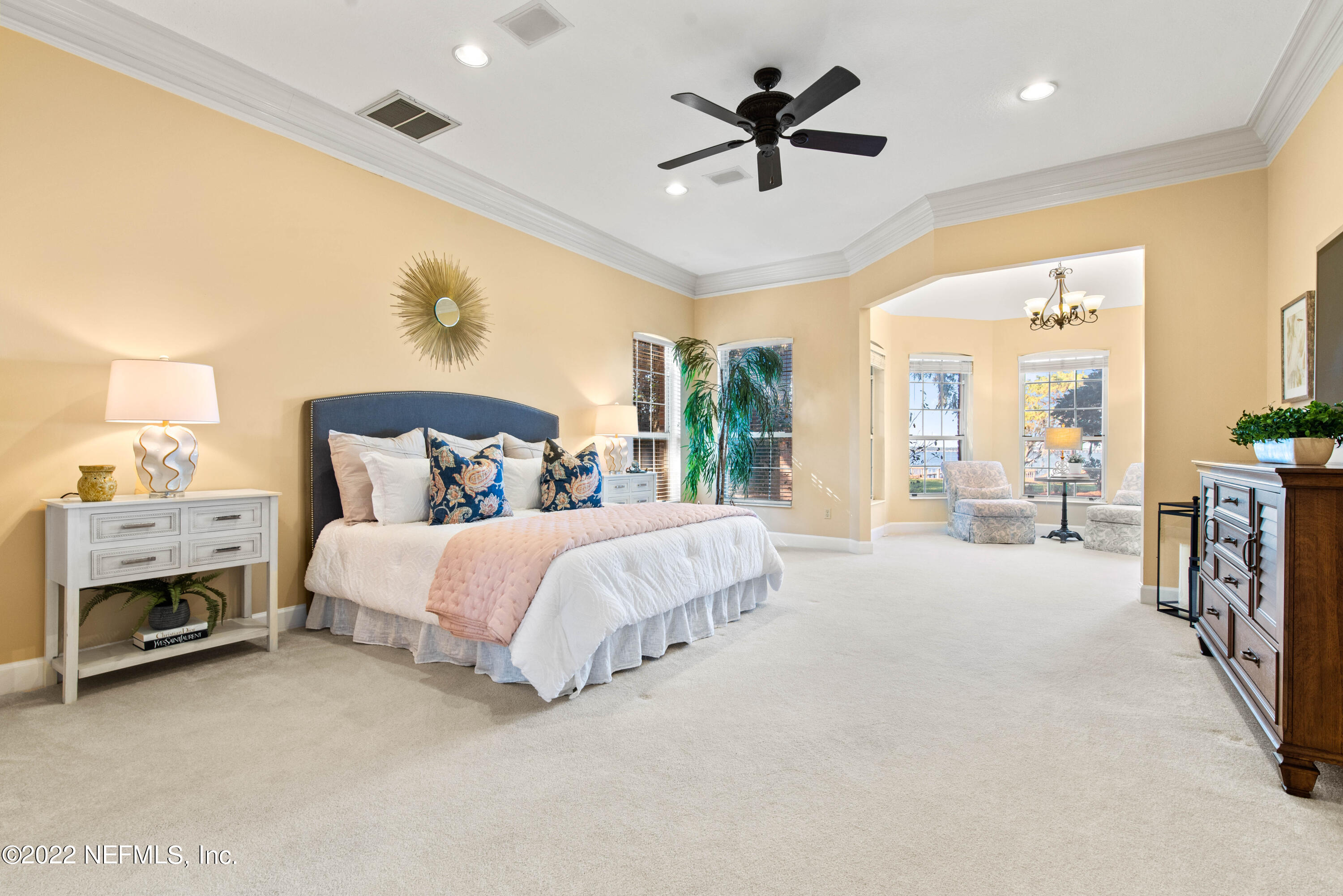 12608 Mandarin Road Jacksonville, FL 32223 - Photo 13 of 55 a spacious bedroom with a large bed and a chandelier fan