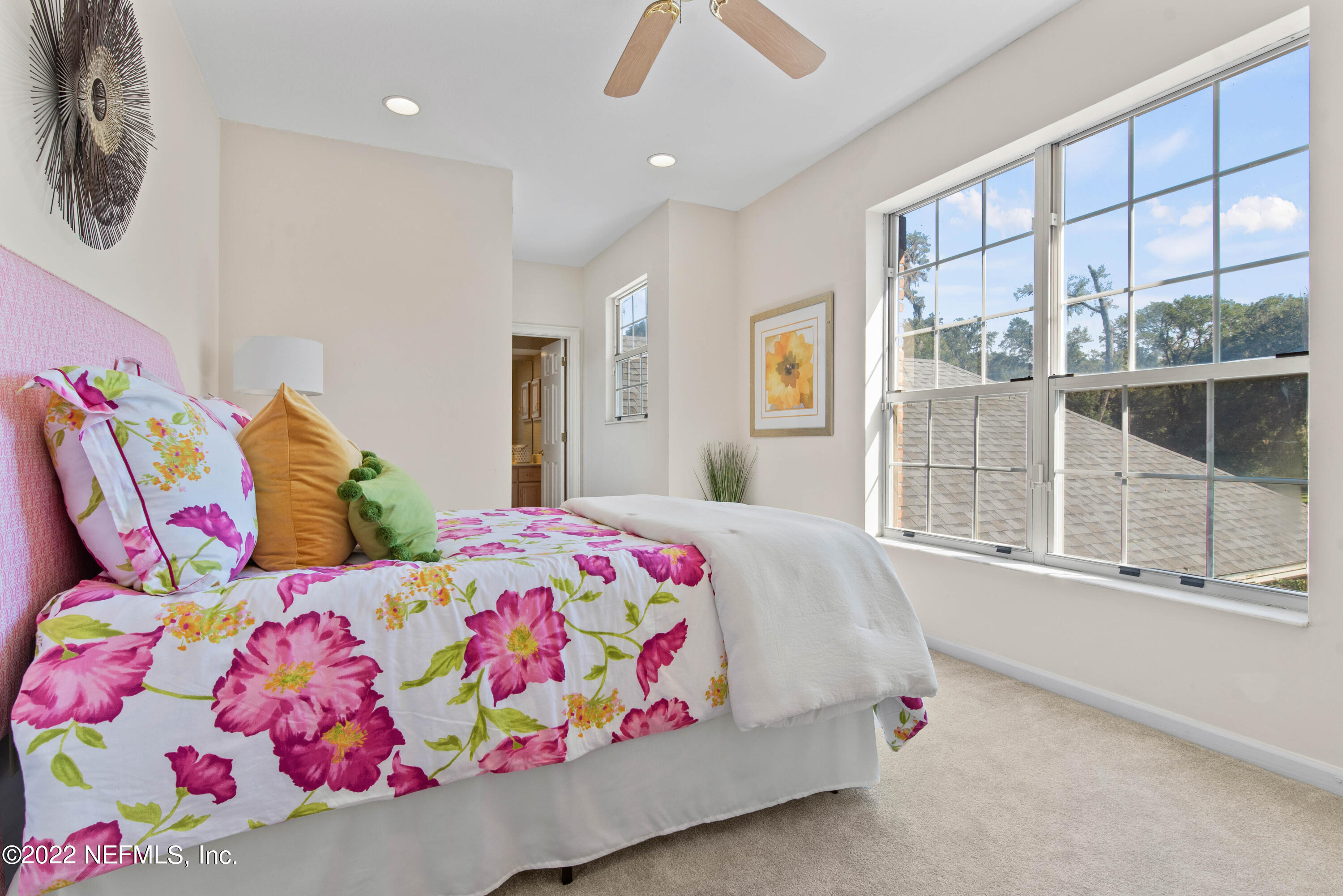 12608 Mandarin Road Jacksonville, FL 32223 - Photo 31 of 55 a bedroom with a bed a dresser and a large window