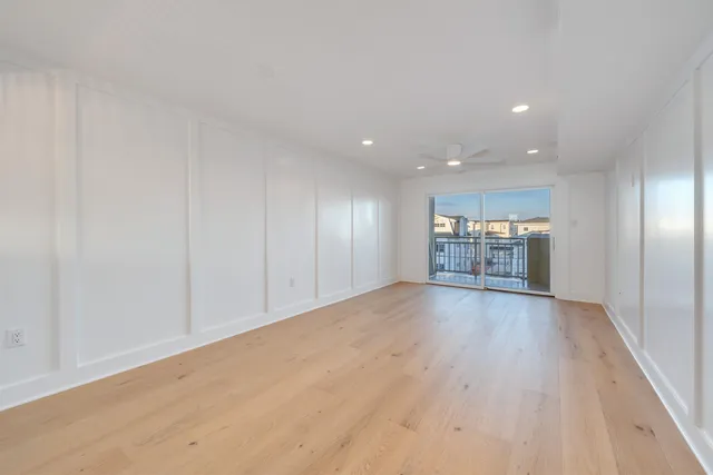 a view of a big room with wooden floor kitchen view and a window