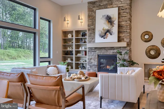 a living room with furniture a fireplace and a large window
