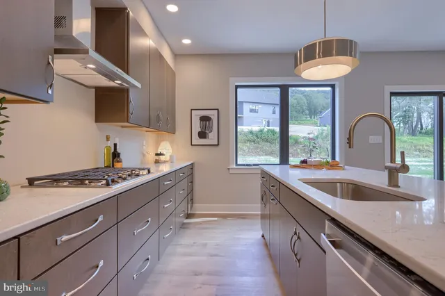 a kitchen with stainless steel appliances granite countertop a sink and a stove