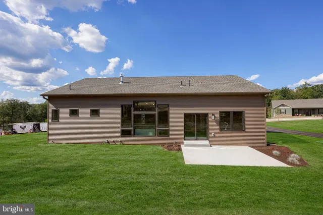 a front view of a house with a garden and yard