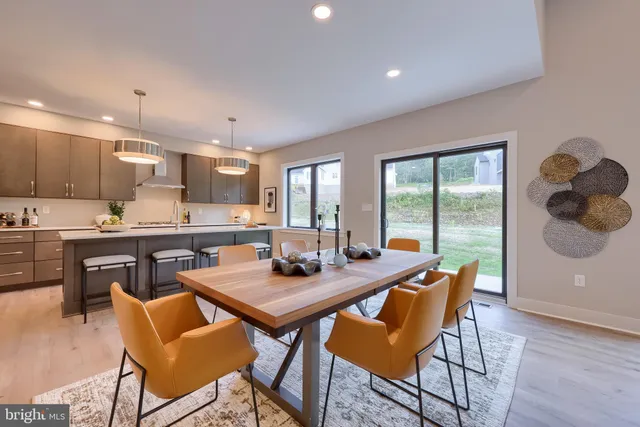 a view of a dining room and livingroom with furniture wooden floor and a rug