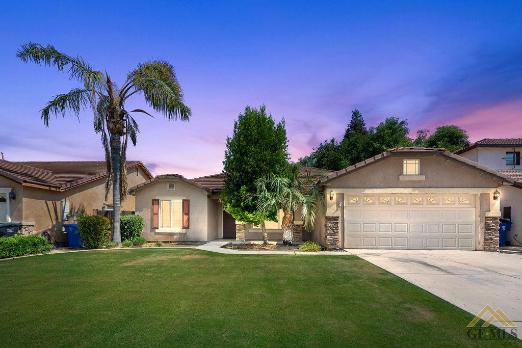 a front view of a house with a garden and yard