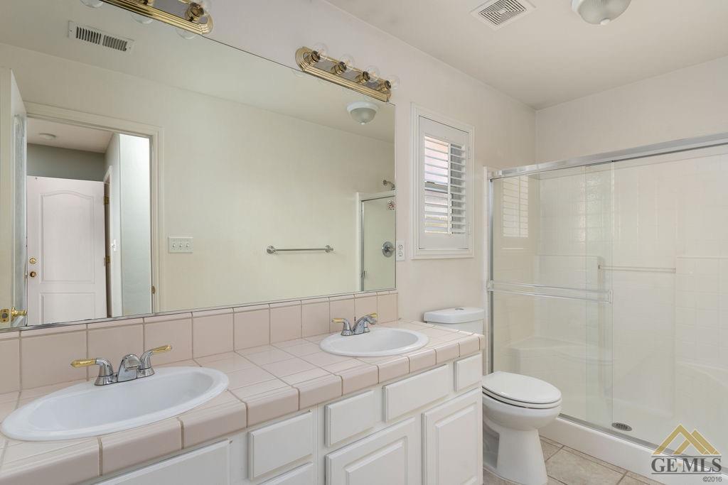 Undisclosed Address Bakersfield, CA 93312 - Photo 14 of 28 a bathroom with a sink a toilet and shower