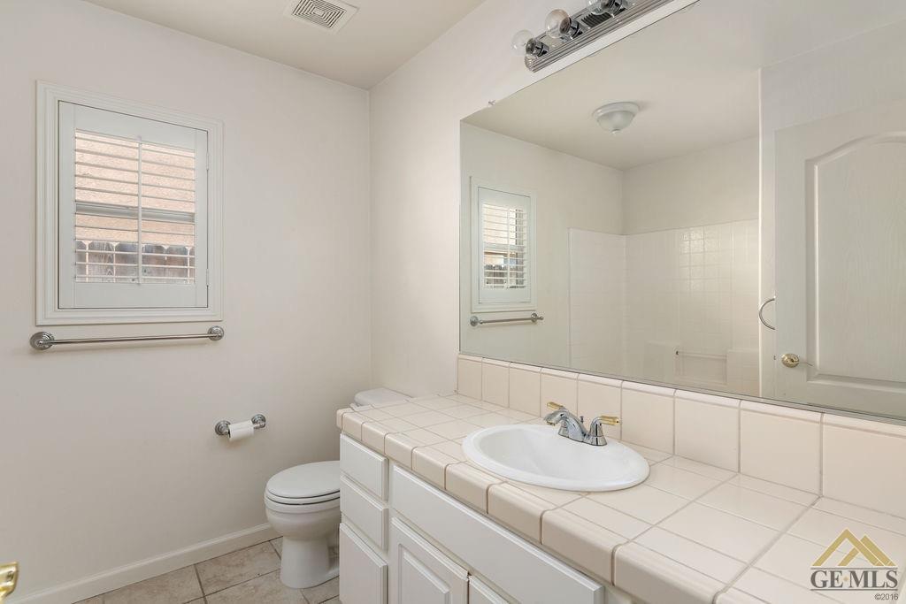 Undisclosed Address Bakersfield, CA 93312 - Photo 17 of 28 a bathroom with a granite countertop sink a toilet and a mirror
