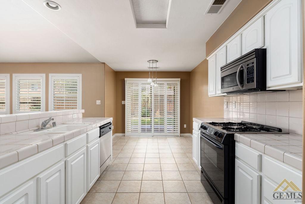 Undisclosed Address Bakersfield, CA 93312 - Photo 7 of 28 a kitchen with stainless steel appliances granite countertop a stove a sink and a microwave