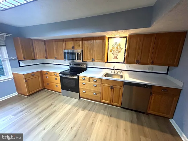 a kitchen with stainless steel appliances granite countertop a sink stove and cabinets