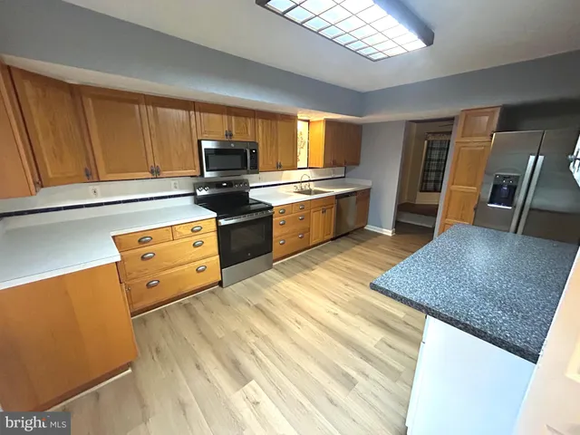 a kitchen with stainless steel appliances granite countertop a sink dishwasher stove and refrigerator