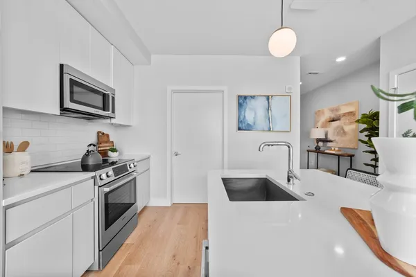 a kitchen with stainless steel appliances a stove a sink and a microwave