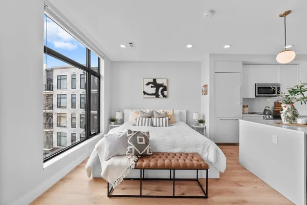 a bedroom with a bed and a large window