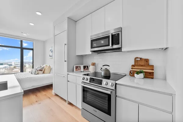 a kitchen with stainless steel appliances granite countertop a stove and a microwave