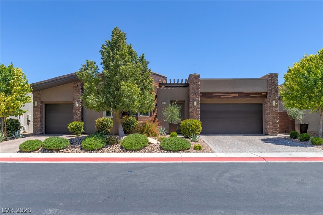 6014 Willow Ridge Court Las Vegas, NV 89135 - Photo 2 of 99 This modern home features an inviting facade with an attached garage and lush landscaping.