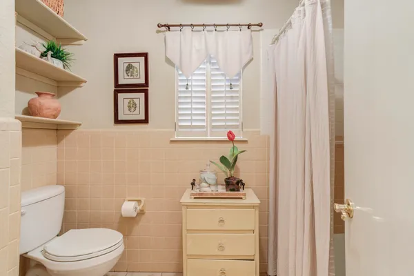 a bathroom with a toilet and a shower curtain