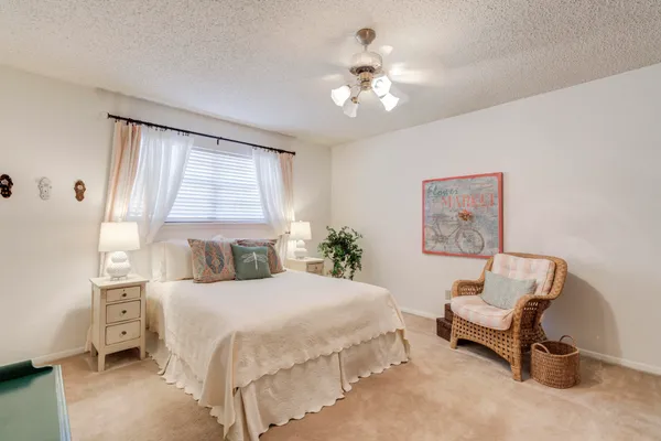 a bedroom with a bed a chair and a chandelier