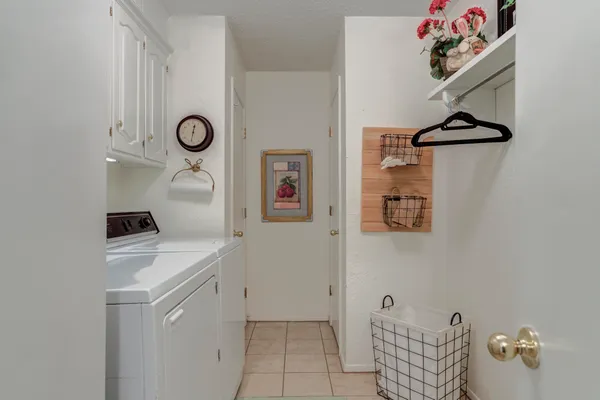 a kitchen with a refrigerator a stove top oven a clock and a window