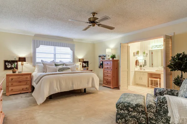 a spacious bedroom with a bed and a chandelier