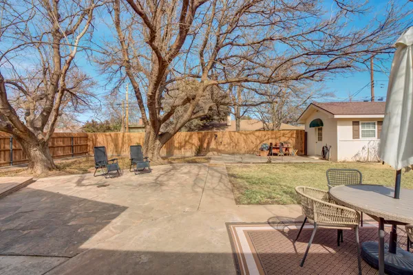 a view of a house with backyard and trees