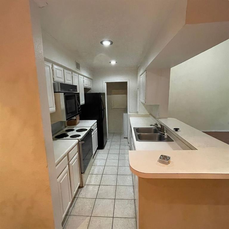 5840 Spring Valley Road, Unit 602 Dallas, TX 75254 - Photo 1 of 1 a kitchen with a sink a stove top oven and white kitchen