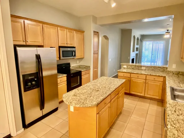 a kitchen with stainless steel appliances granite countertop a refrigerator and a stove top oven