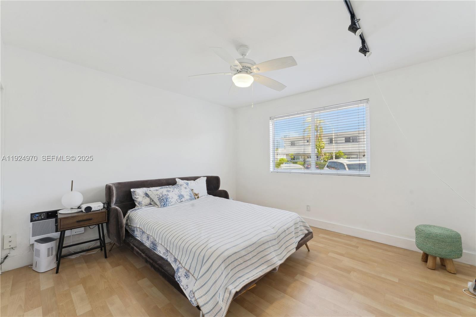 7440 Byron Avenue, Unit 1B Miami Beach, FL 33141 - Photo 11 of 16 a bedroom with a bed and a chair